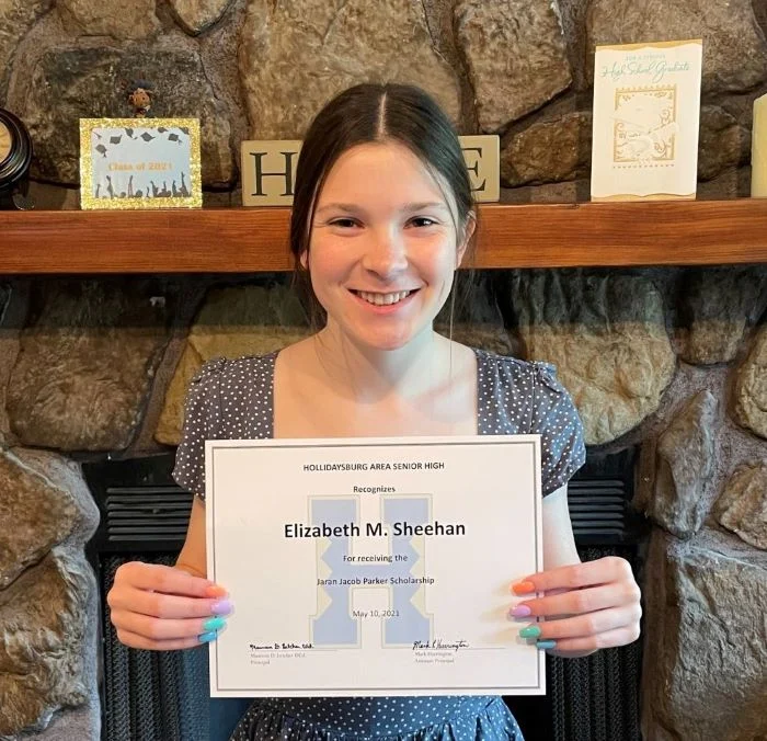 Scholarship recipient holding an award certificate